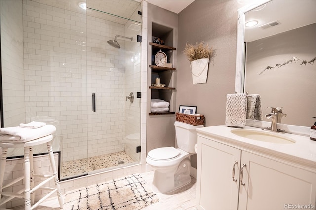 bathroom featuring vanity, toilet, a shower with shower door, and built in features