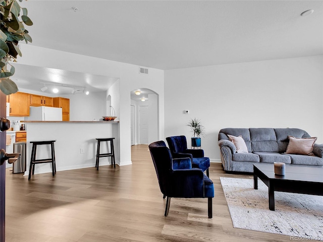 5765 N Genoa Way Unit 1-103, Aurora, CO 80019 - living area featuring arched walkways, wood finished floors, and baseboards