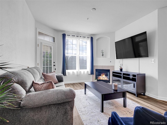 5765 N Genoa Way Unit 1-103, Aurora, CO 80019 - living room with wood finished floors, a tile fireplace, and baseboards
