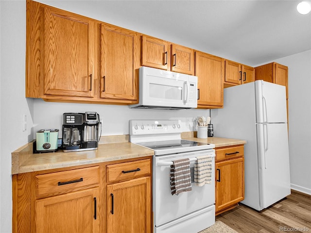 5765 N Genoa Way Unit 1-103, Aurora, CO 80019 - kitchen featuring white appliances, light countertops, wood finished floors, and brown cabinetry