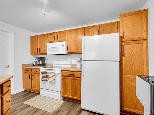 5765 N Genoa Way Unit 1-103, Aurora, CO 80019 - kitchen with white appliances, light wood-style flooring, light countertops, and brown cabinetry