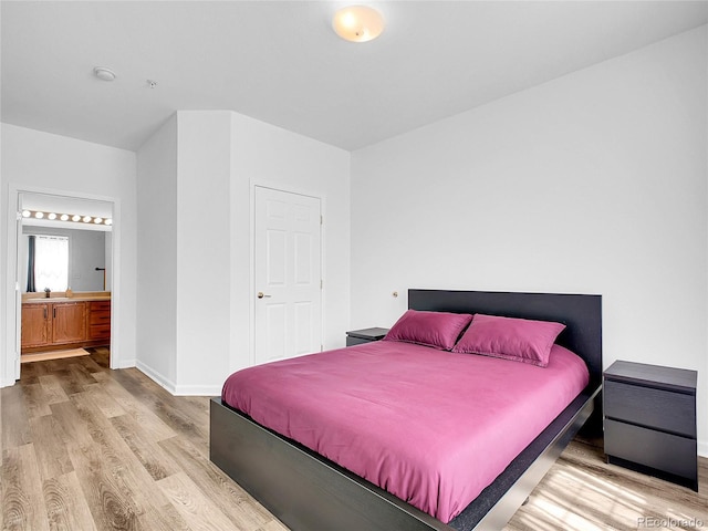 5765 N Genoa Way Unit 1-103, Aurora, CO 80019 - bedroom featuring wood finished floors, baseboards, and connected bathroom