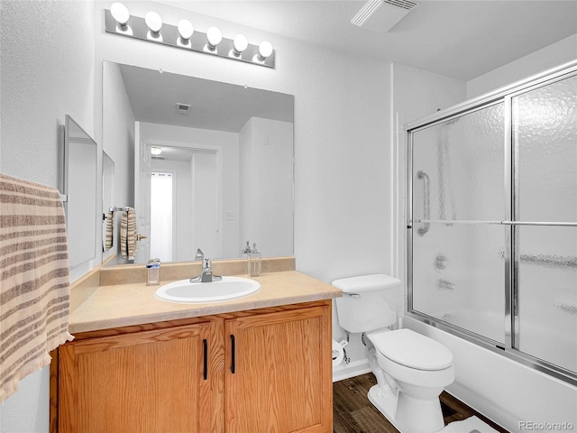 5765 N Genoa Way Unit 1-103, Aurora, CO 80019 - bathroom featuring toilet, vanity, shower / bath combination with glass door, and wood finished floors