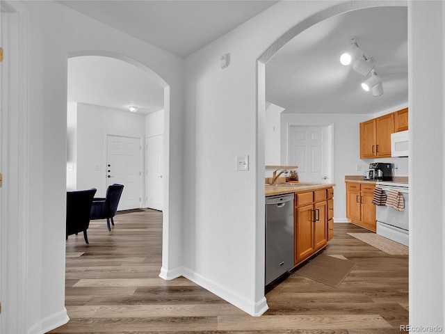 5765 N Genoa Way Unit 1-103, Aurora, CO 80019 - kitchen with stainless steel dishwasher, arched walkways, white microwave, electric stove, and light countertops