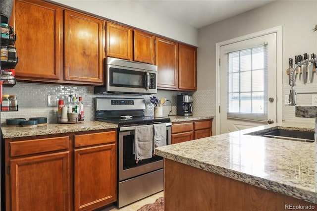 8220 W 90th Pl Unit 2003, Broomfield, CO 80021 - kitchen with stainless steel appliances, backsplash, a sink, and brown cabinets
