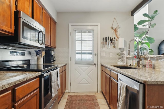 8220 W 90th Pl Unit 2003, Broomfield, CO 80021 - kitchen featuring stainless steel appliances, a sink, decorative backsplash, and light tile patterned flooring