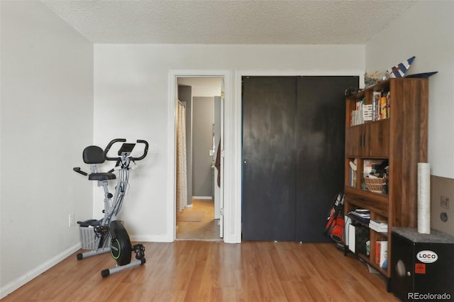8220 W 90th Pl Unit 2003, Broomfield, CO 80021 - workout room featuring wood finished floors, a textured ceiling, and baseboards