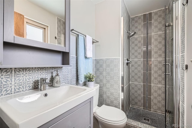 bathroom featuring vanity, tasteful backsplash, tile walls, toilet, and walk in shower