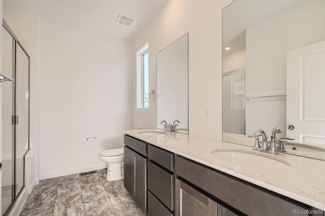 bathroom with vanity, toilet, and a shower with shower door