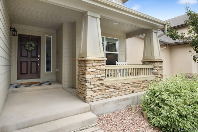 9135 Argentine Pass Trl, Colorado Springs, CO 80924 - property entrance featuring stone siding, stucco siding, and covered porch