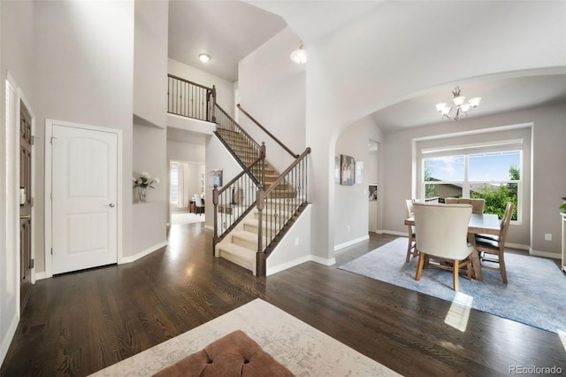 9135 Argentine Pass Trl, Colorado Springs, CO 80924 - entrance foyer with arched walkways, a high ceiling, a chandelier, wood finished floors, and stairs