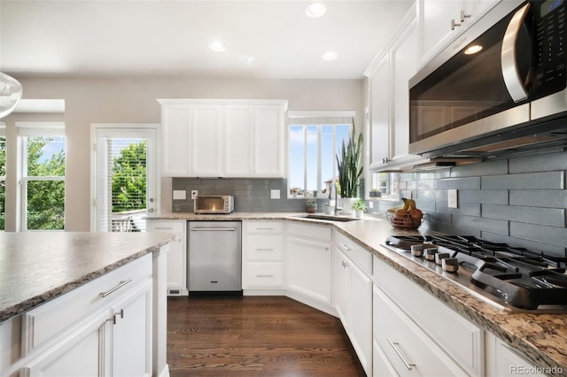 9135 Argentine Pass Trl, Colorado Springs, CO 80924 - kitchen with appliances with stainless steel finishes, recessed lighting, backsplash, white cabinetry, and dark wood-style floors