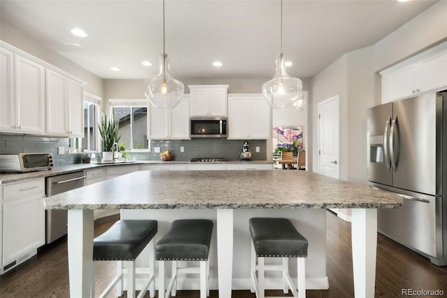 9135 Argentine Pass Trl, Colorado Springs, CO 80924 - kitchen featuring stainless steel appliances, a center island, tasteful backsplash, white cabinets, and recessed lighting