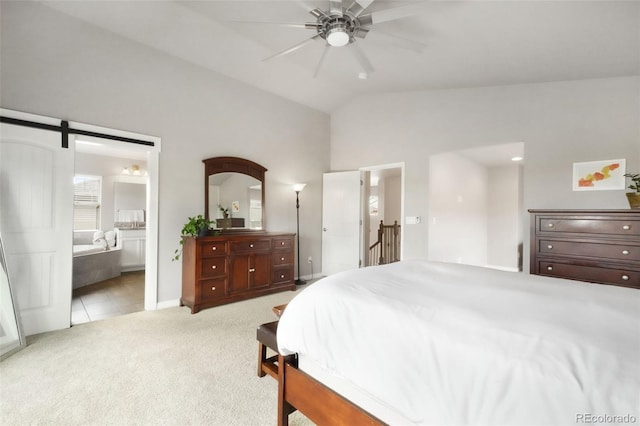 9135 Argentine Pass Trl, Colorado Springs, CO 80924 - bedroom featuring light colored carpet, vaulted ceiling, ensuite bathroom, a barn door, and a ceiling fan