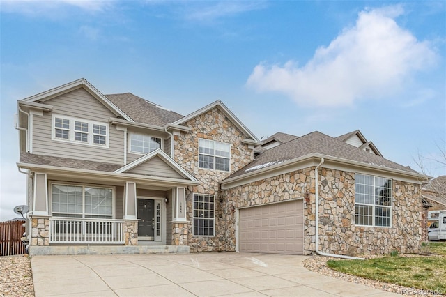 craftsman-style home featuring concrete driveway, stone siding, and roof with shingles
