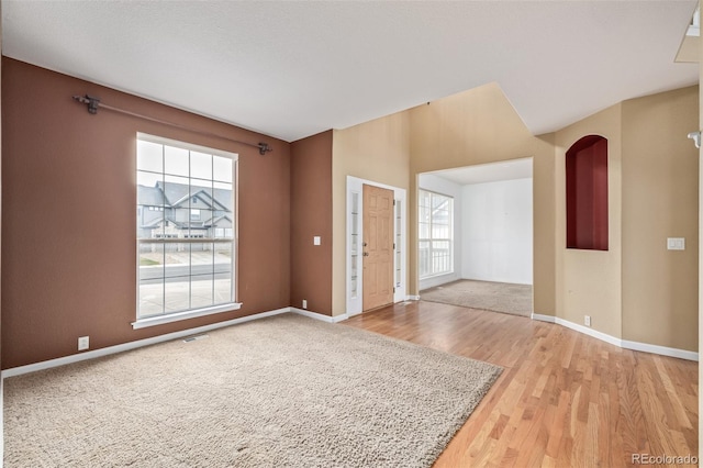 empty room featuring light wood finished floors, baseboards, and visible vents