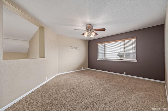 spare room featuring a textured ceiling, baseboards, a ceiling fan, and carpet