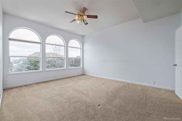empty room with visible vents, carpet floors, ceiling fan, and baseboards