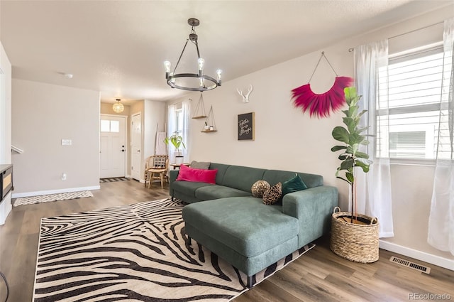 442 Stardust Ct, Dacono, CO 80514 - living room with visible vents, baseboards, an inviting chandelier, and wood finished floors