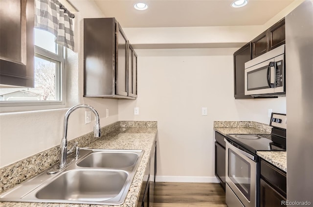442 Stardust Ct, Dacono, CO 80514 - kitchen featuring baseboards, a sink, dark brown cabinets, wood finished floors, and stainless steel appliances