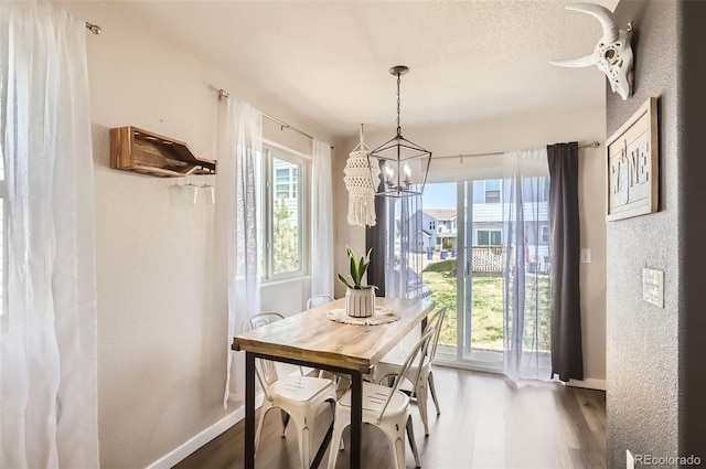 442 Stardust Ct, Dacono, CO 80514 - dining space with wood finished floors, a notable chandelier, and baseboards