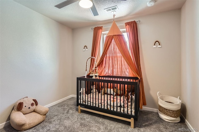 442 Stardust Ct, Dacono, CO 80514 - carpeted bedroom with visible vents, baseboards, a ceiling fan, a crib, and a textured ceiling