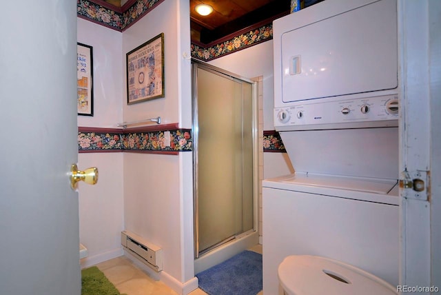 laundry room with a baseboard radiator, stacked washing maching and dryer, and light tile patterned floors