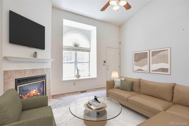 carpeted living area featuring a fireplace, lofted ceiling, a ceiling fan, and baseboards