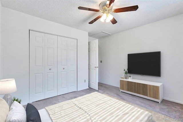 bedroom featuring carpet, a textured ceiling, a closet, and ceiling fan