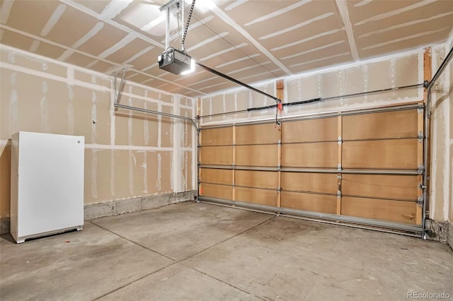 garage featuring a garage door opener and freestanding refrigerator