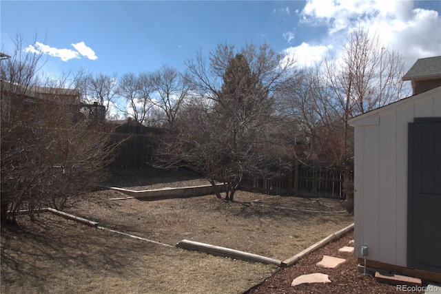 view of yard with an outbuilding, fence, and a storage unit