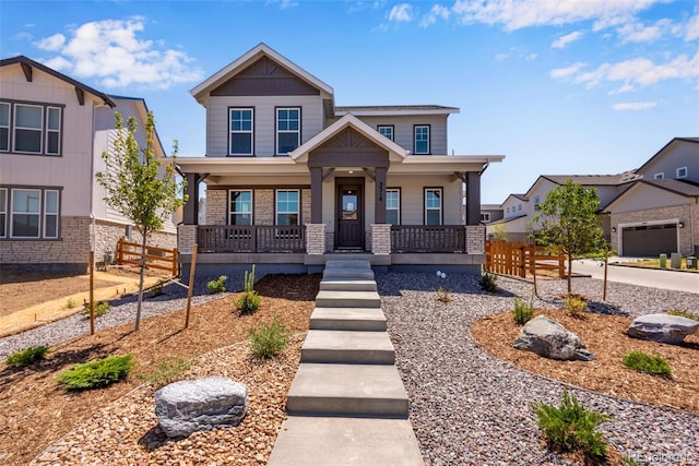 craftsman-style house with covered porch, fence, and brick siding