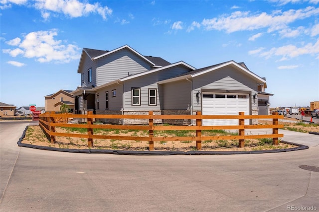 single story home featuring a garage, driveway, and a fenced front yard