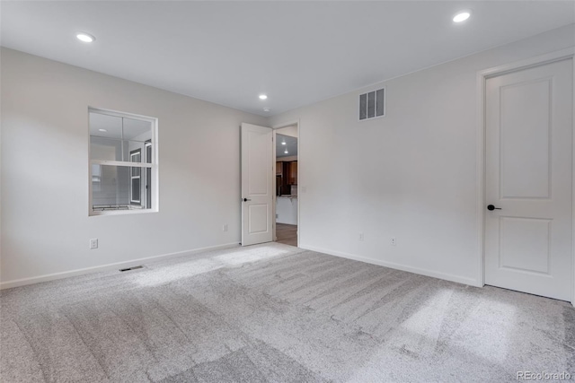 spare room featuring carpet floors, baseboards, visible vents, and recessed lighting