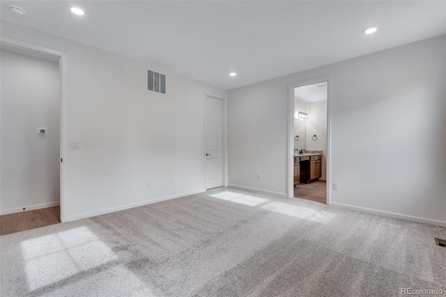 spare room with recessed lighting, visible vents, light carpet, and baseboards