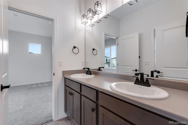 bathroom featuring double vanity, a sink, and baseboards