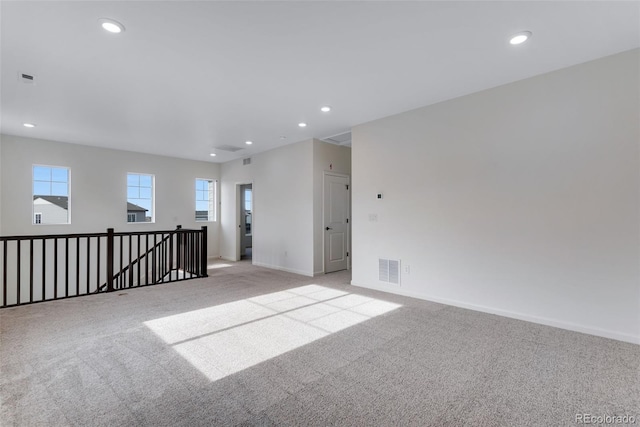 empty room with recessed lighting, visible vents, and light colored carpet