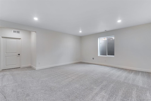 spare room with recessed lighting, light colored carpet, visible vents, and baseboards