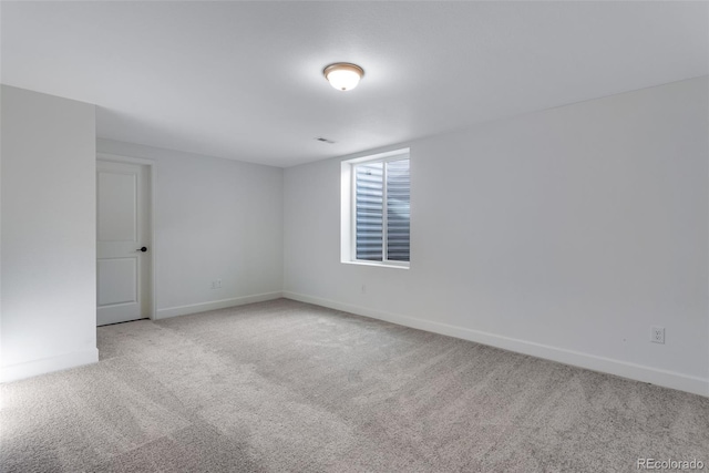 carpeted spare room featuring baseboards