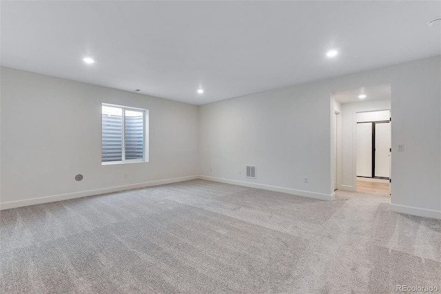 spare room with baseboards, recessed lighting, visible vents, and light colored carpet