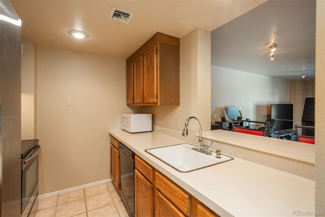 kitchen with dishwasher, stove, sink, light tile patterned floors, and kitchen peninsula