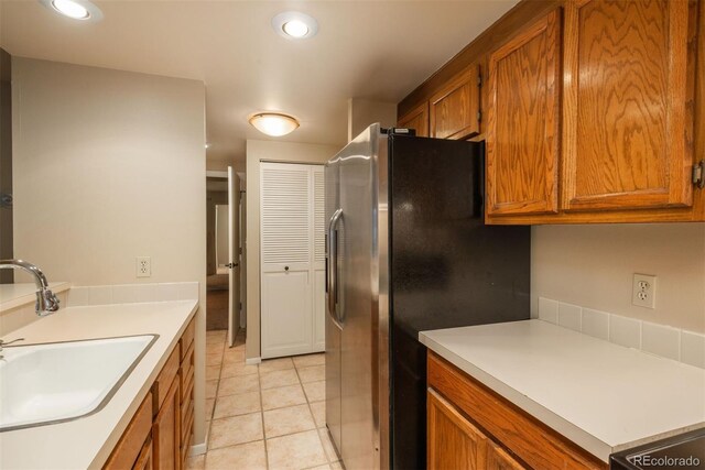 kitchen with stainless steel fridge with ice dispenser, sink, and light tile patterned floors