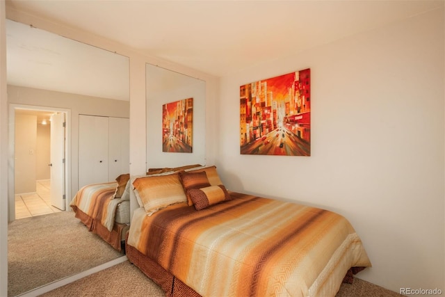 bedroom with connected bathroom, light colored carpet, and a closet