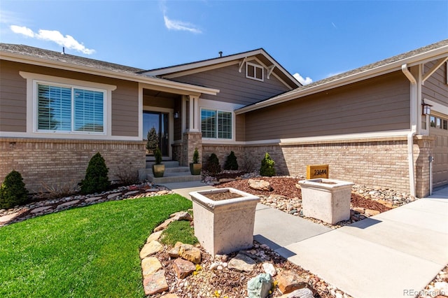 view of front of house with a front lawn, brick siding, and driveway