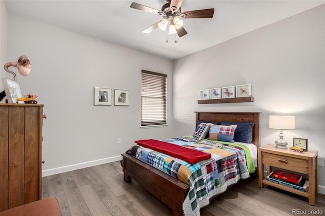 bedroom with ceiling fan, baseboards, and wood finished floors