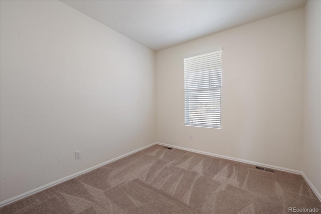 spare room with visible vents, carpet, and baseboards