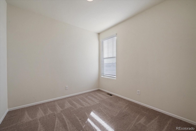 carpeted spare room with visible vents and baseboards