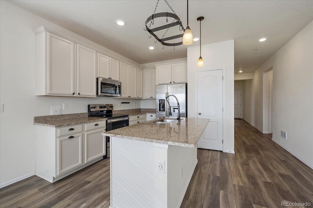 kitchen featuring visible vents, a kitchen island with sink, a sink, stainless steel appliances, and white cabinetry