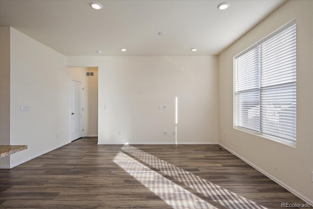 spare room with recessed lighting, dark wood-style floors, visible vents, and baseboards