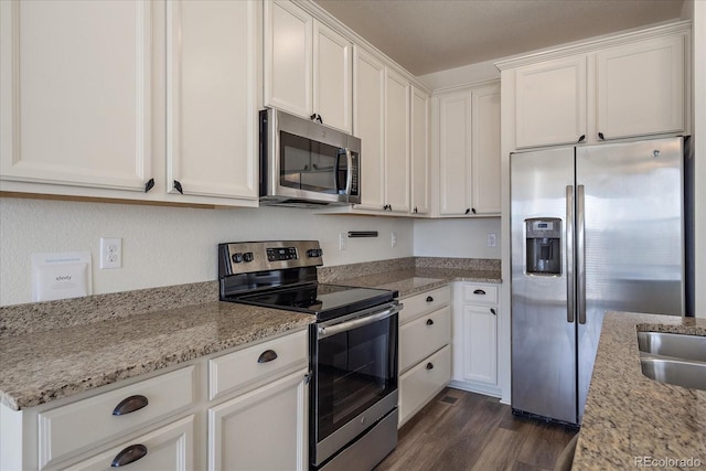 kitchen featuring light stone counters, white cabinets, stainless steel appliances, and dark wood-style flooring